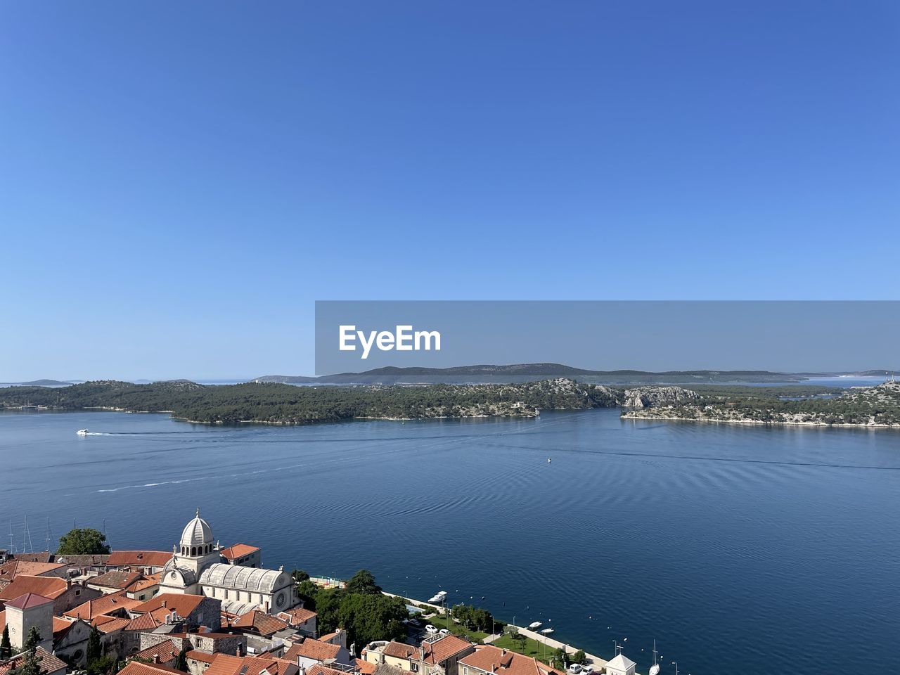 water, sky, architecture, clear sky, sea, nature, blue, built structure, travel destinations, building exterior, building, scenics - nature, copy space, coast, land, travel, no people, city, sunny, bay, day, beauty in nature, shore, tourism, environment, high angle view, beach, tranquility, landscape, outdoors, body of water, house, tranquil scene, vacation, sunlight, residential district, trip, mountain, horizon, summer, transportation, town, cityscape, reservoir