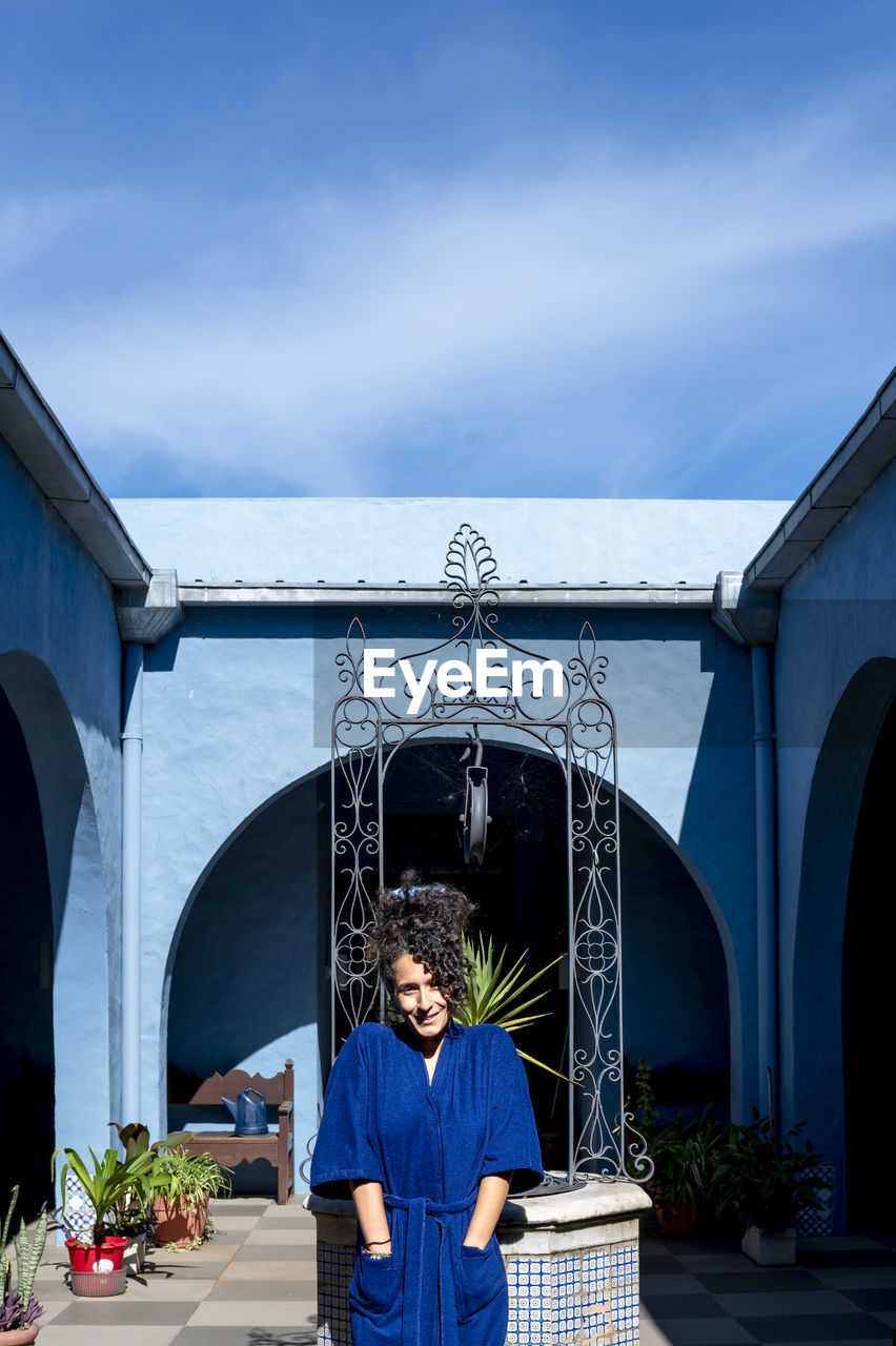 Woman posing in robe outdoors in a countryside house.