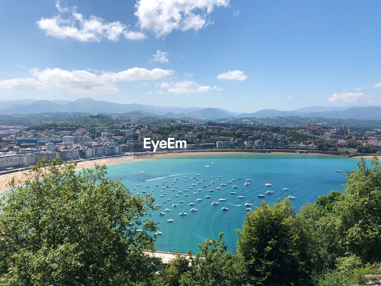 High angle view of city by sea against sky