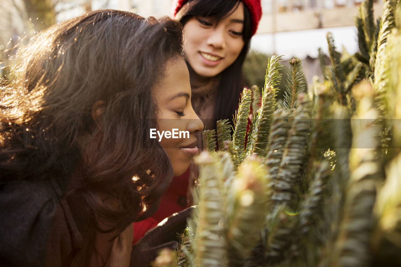 Woman with eyes closed examining christmas tree in display