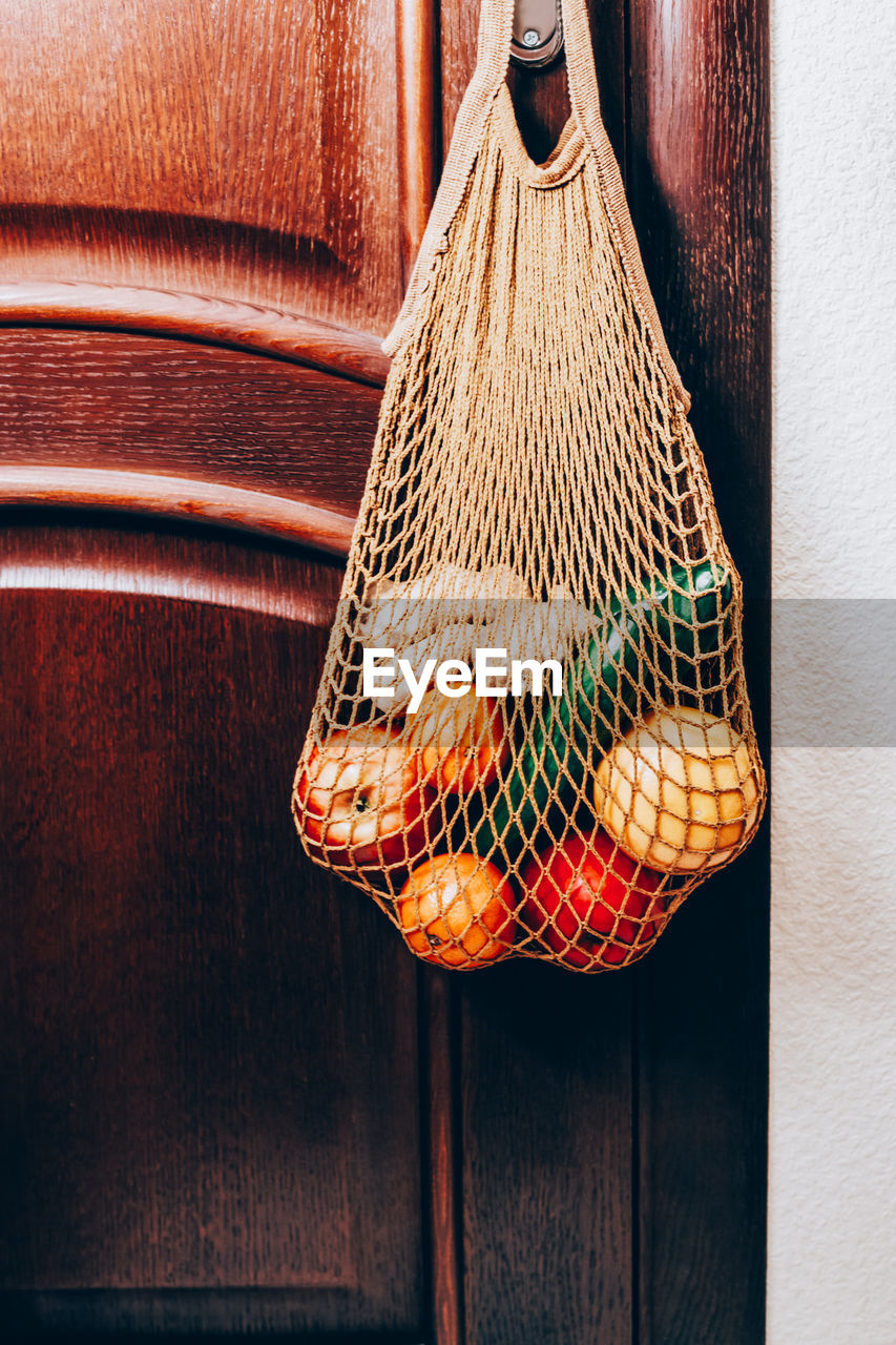 CLOSE-UP OF ORANGE HANGING ON TABLE