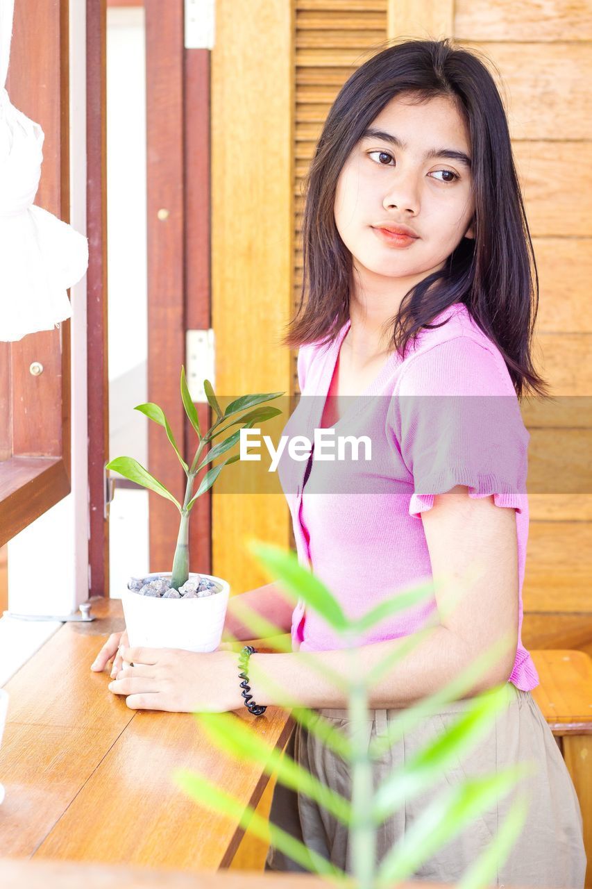 Portrait of beautiful woman standing on table. new normal lifestyle. stay home with nature.