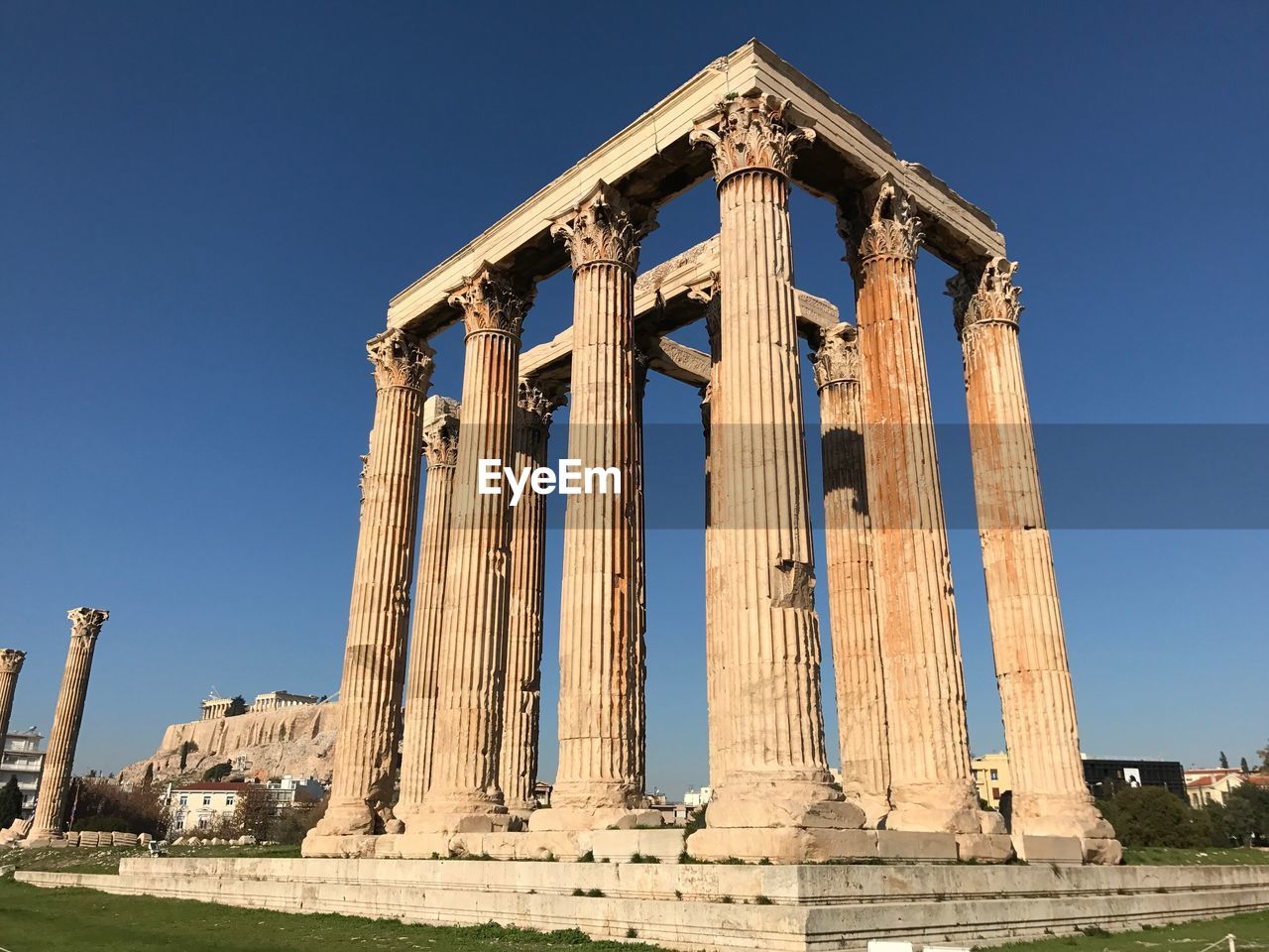 Low angle view of zeus temple against blue sky on sunny day