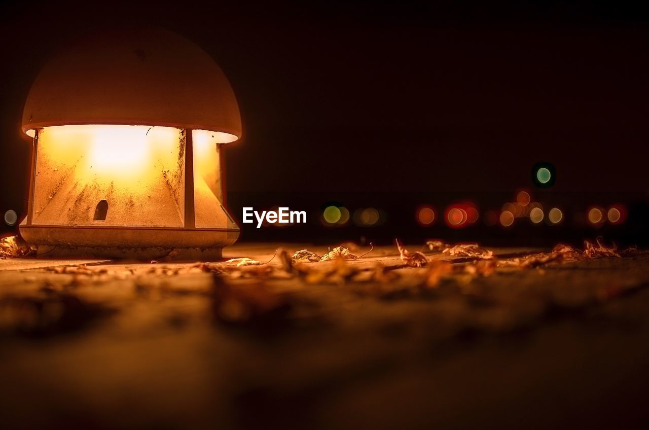 CLOSE-UP OF ILLUMINATED LIGHTS AGAINST SKY