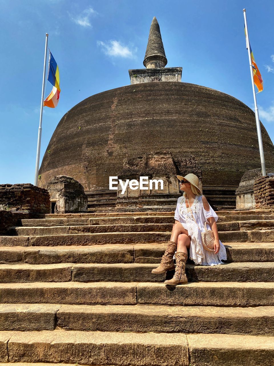 Full length of woman sitting on steps at historic place