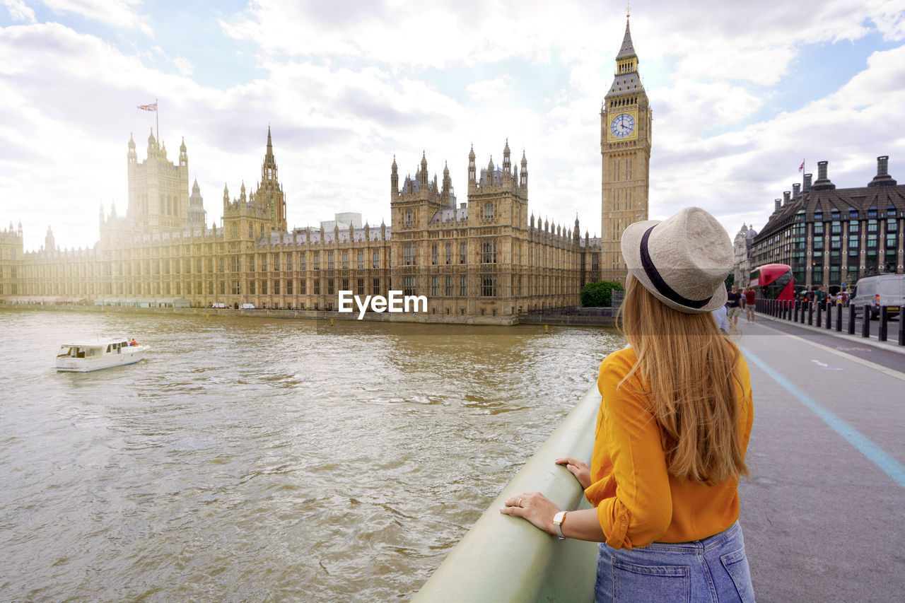 Traveler girl enjoying sight of westminster palace and bridge on thames with big ben tower in london