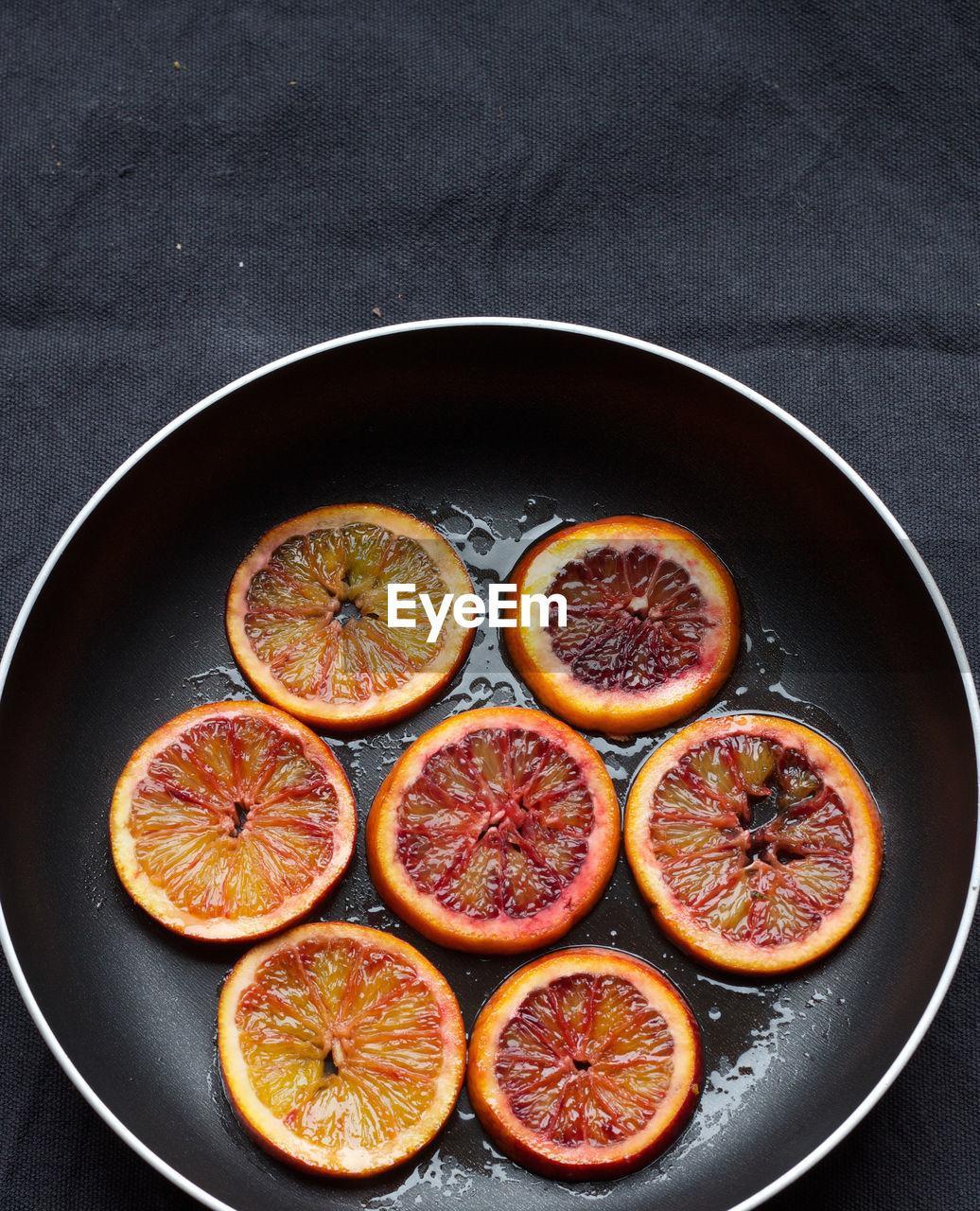 High angle view of caramelized blood orange slices in saucepan