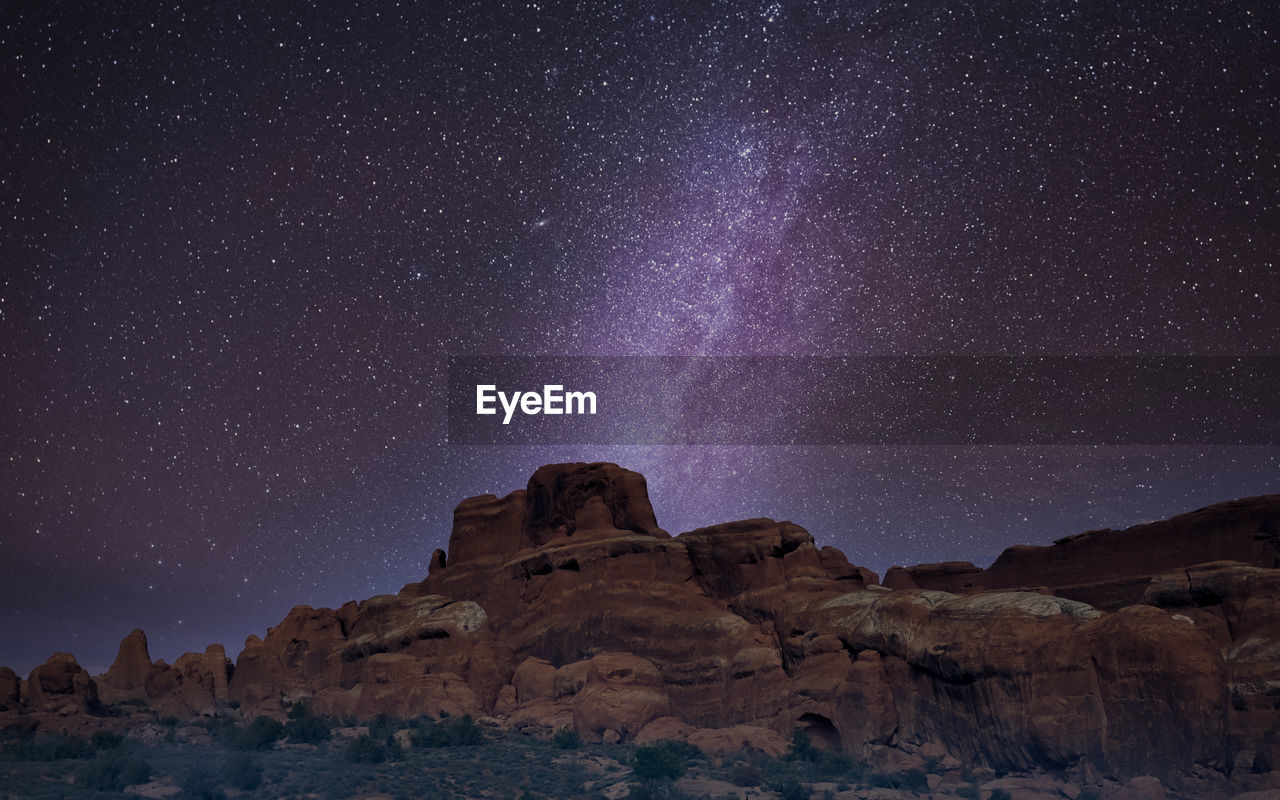 Scenic view of rock formation in desert against sky at night