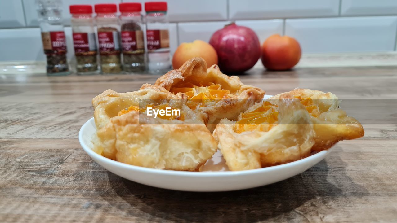 food and drink, food, dish, freshness, produce, breakfast, indoors, table, healthy eating, fruit, meal, fast food, no people, cuisine, wellbeing, dessert, wood, focus on foreground, close-up, sweet food, baked, still life, bowl, apple - fruit, plate