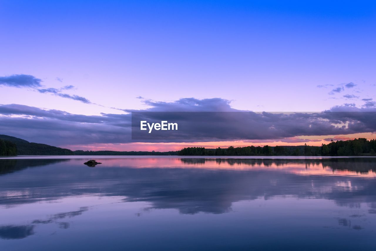 Scenic view of lake against sky at sunset