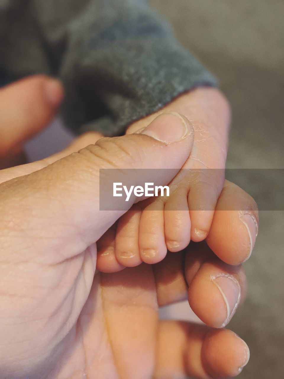 CLOSE-UP OF HAND HOLDING BABY FEET