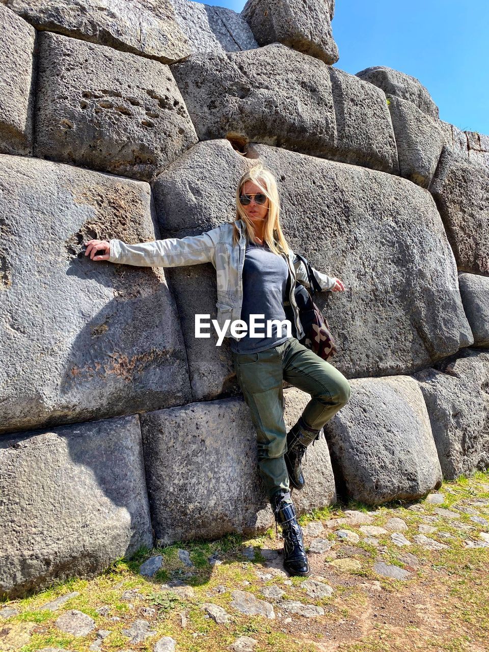 FULL LENGTH PORTRAIT OF YOUNG WOMAN ON ROCK