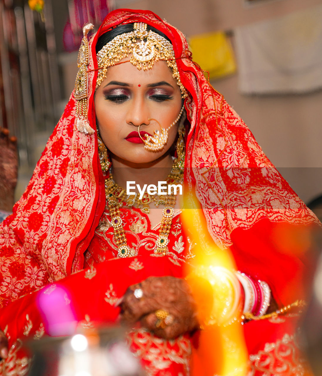 Close-up of bride wearing traditional clothing sitting in wedding ceremony