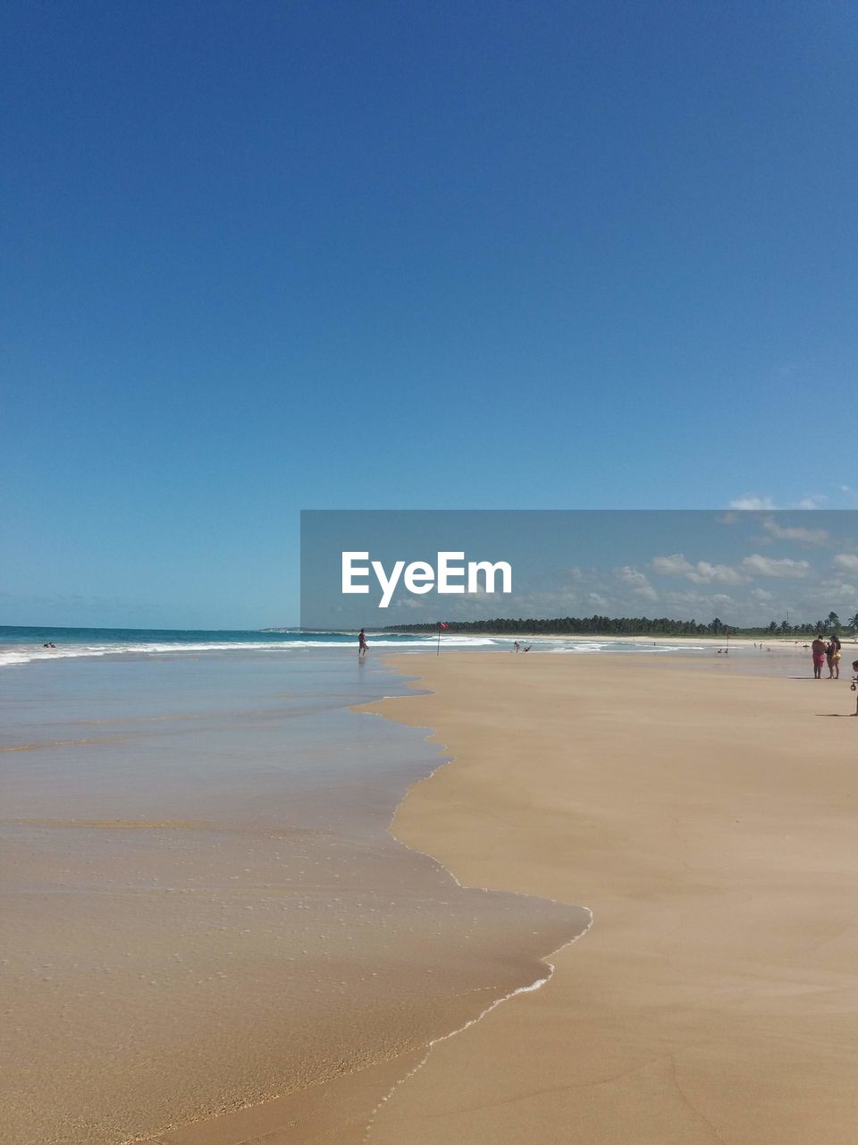 Scenic view of beach against clear blue sky