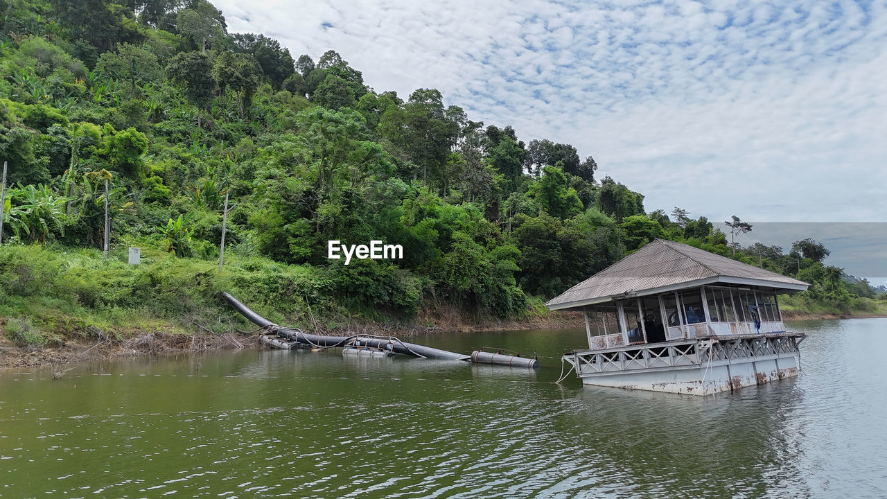 water, tree, plant, architecture, built structure, nature, beauty in nature, river, scenics - nature, tranquility, house, no people, building, building exterior, travel destinations, stilt house, hut, day, tranquil scene, travel, nautical vessel, mountain, land, sky, outdoors, tropical climate, tourism, landscape, environment, idyllic, non-urban scene, green, cloud, transportation, forest, residential district, vacation, reservoir, beach, waterfront, bay, holiday, trip, growth