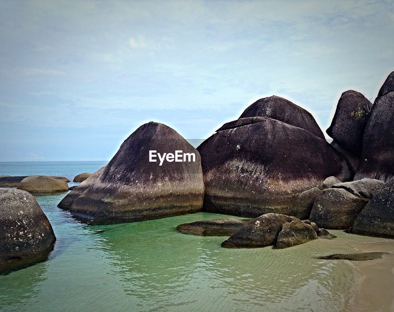 Rocks by sea against sky