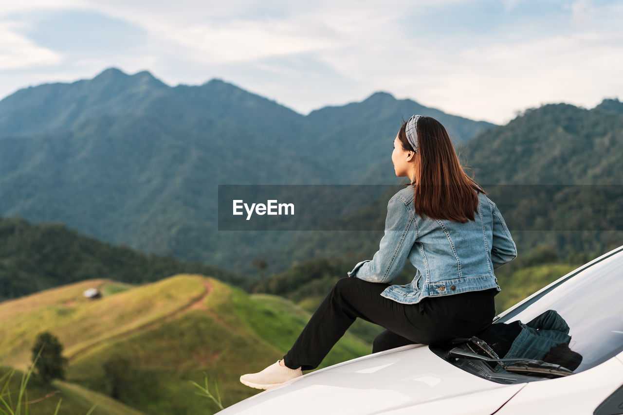 WOMAN SITTING ON A MOUNTAIN