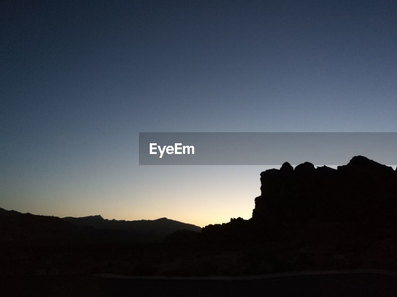 SILHOUETTE OF MOUNTAINS AGAINST CLEAR SKY