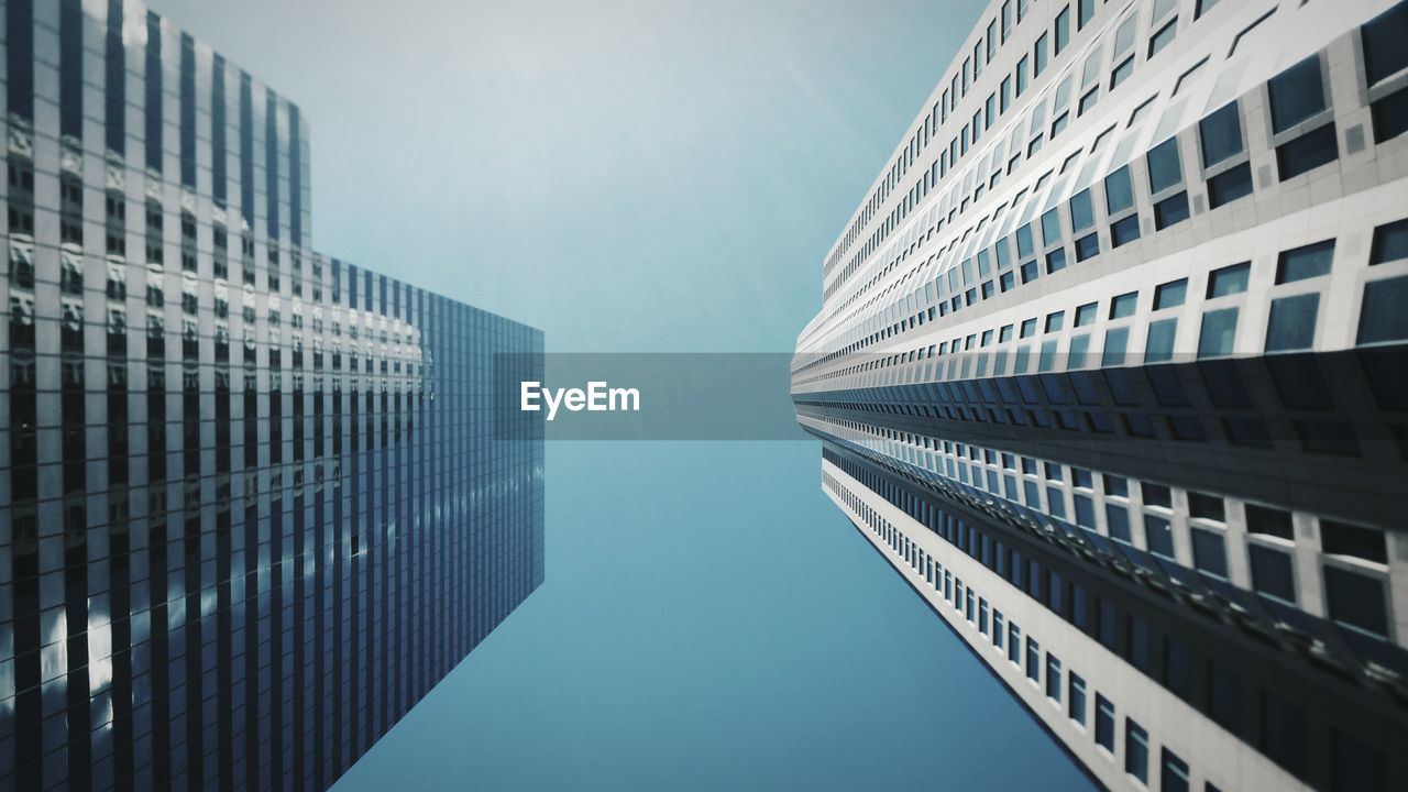 Low angle view of modern buildings against blue sky