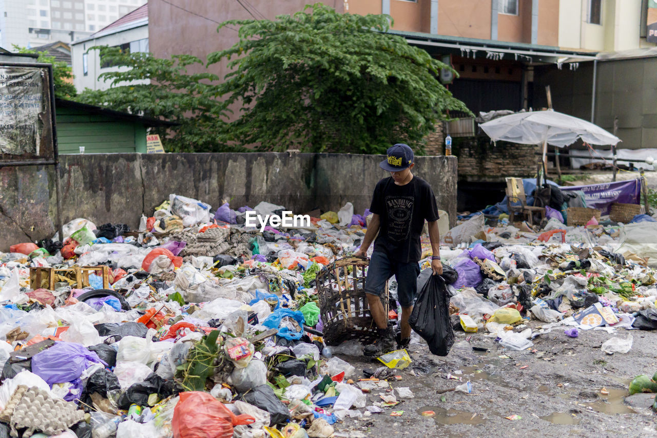 Man walking by garbage dump