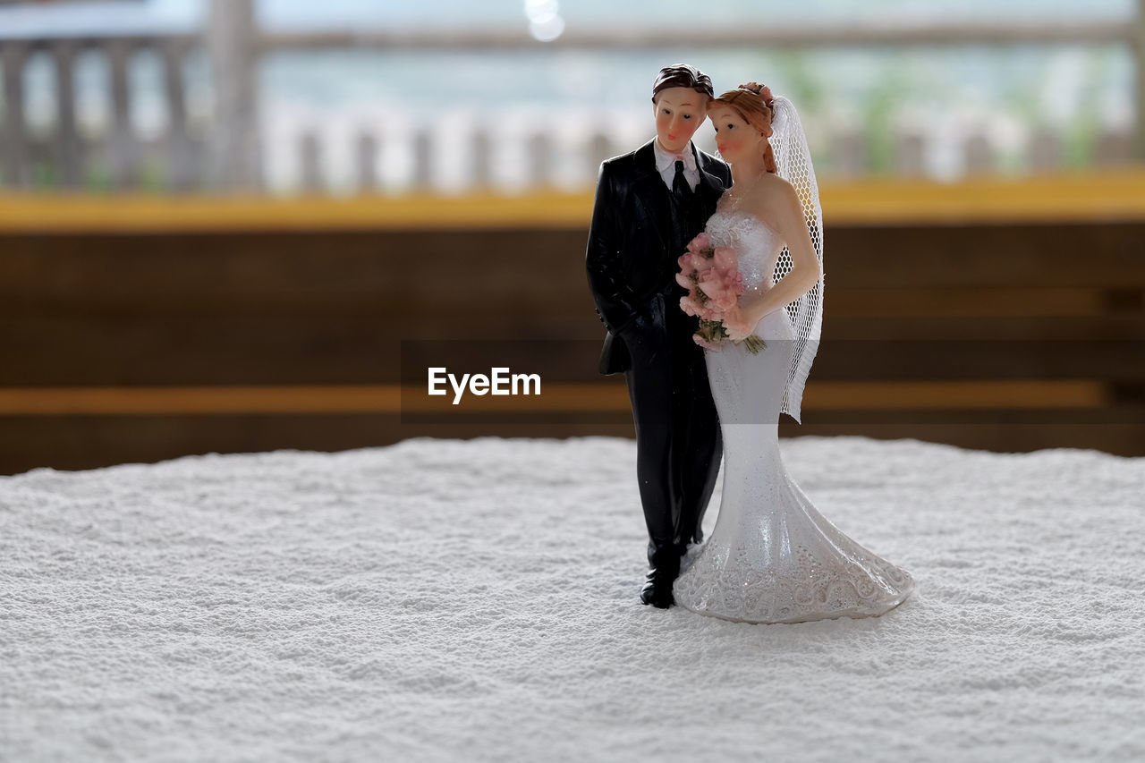 Close-up of wedding couple figurine on tablecloth