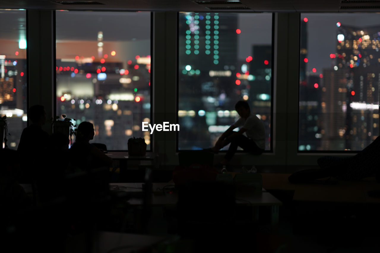 SILHOUETTE PEOPLE IN ILLUMINATED RESTAURANT