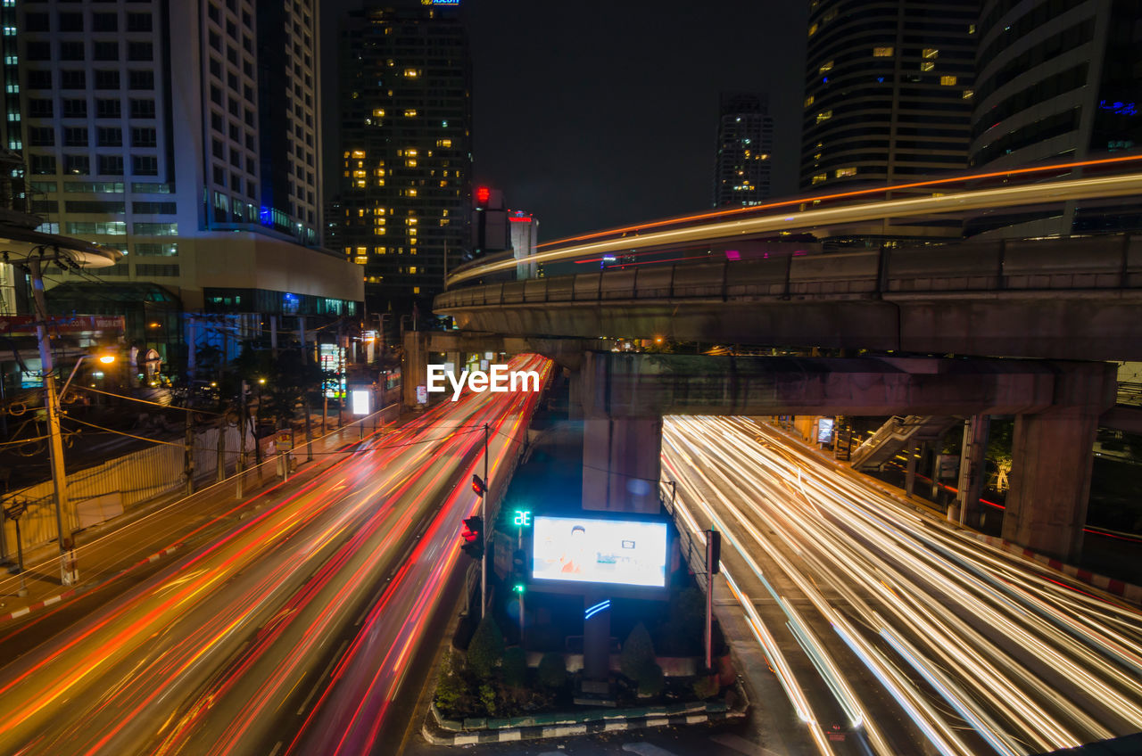 Light trails on road along buildings at night