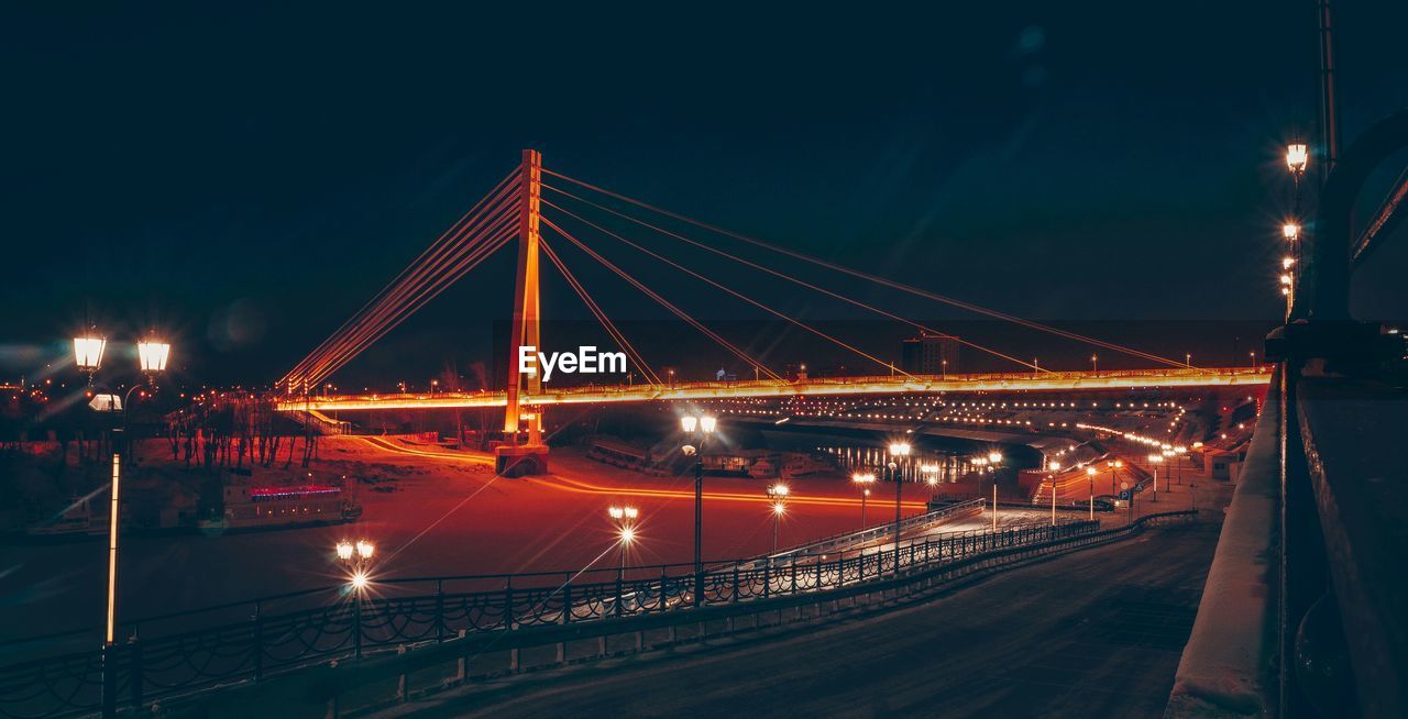 Illuminated bridge against sky at night