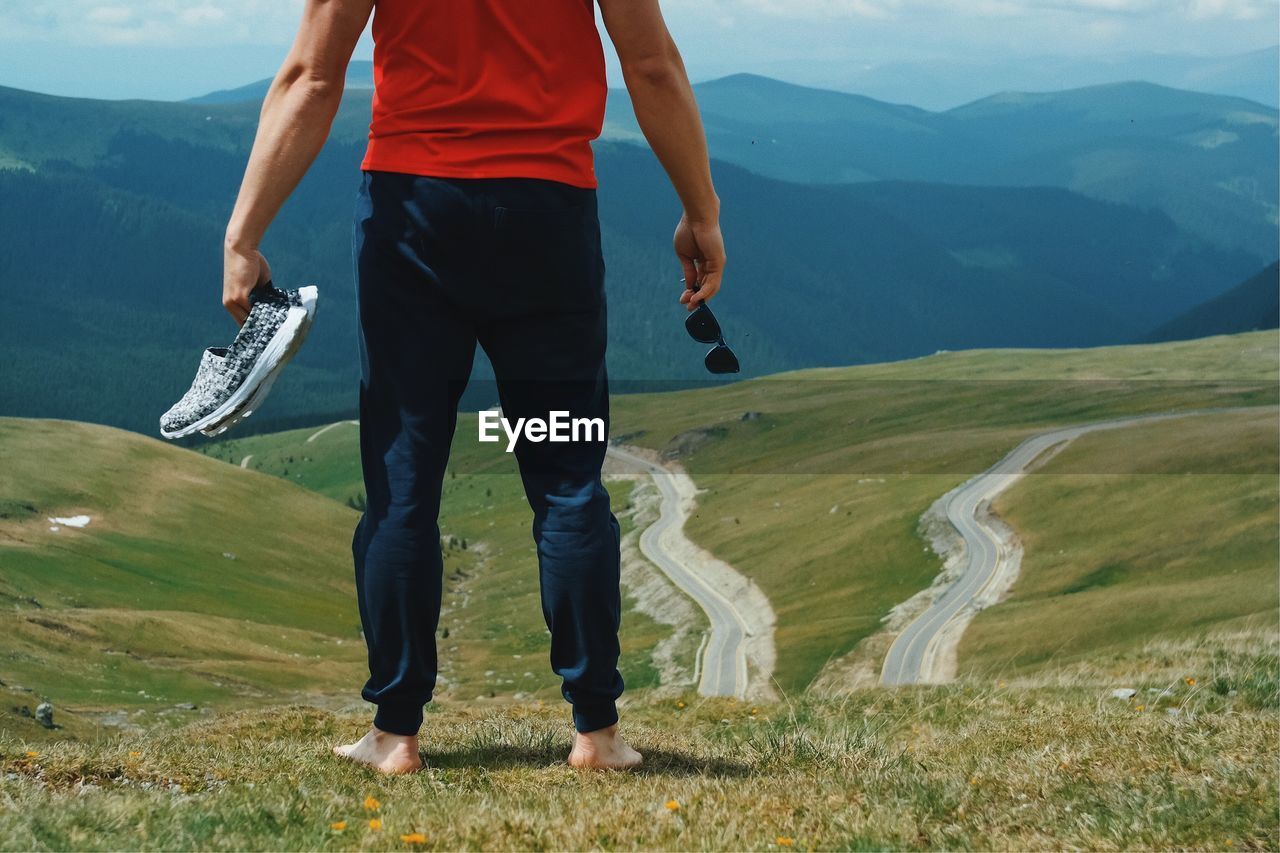 Low section of man standing on mountain