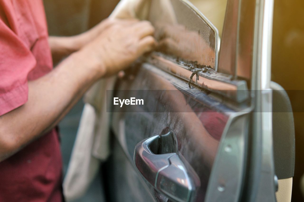Midsection of mechanic repairing car