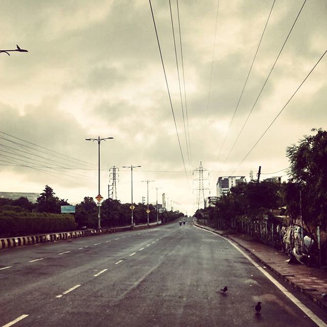 POWER LINES AGAINST CLOUDY SKY