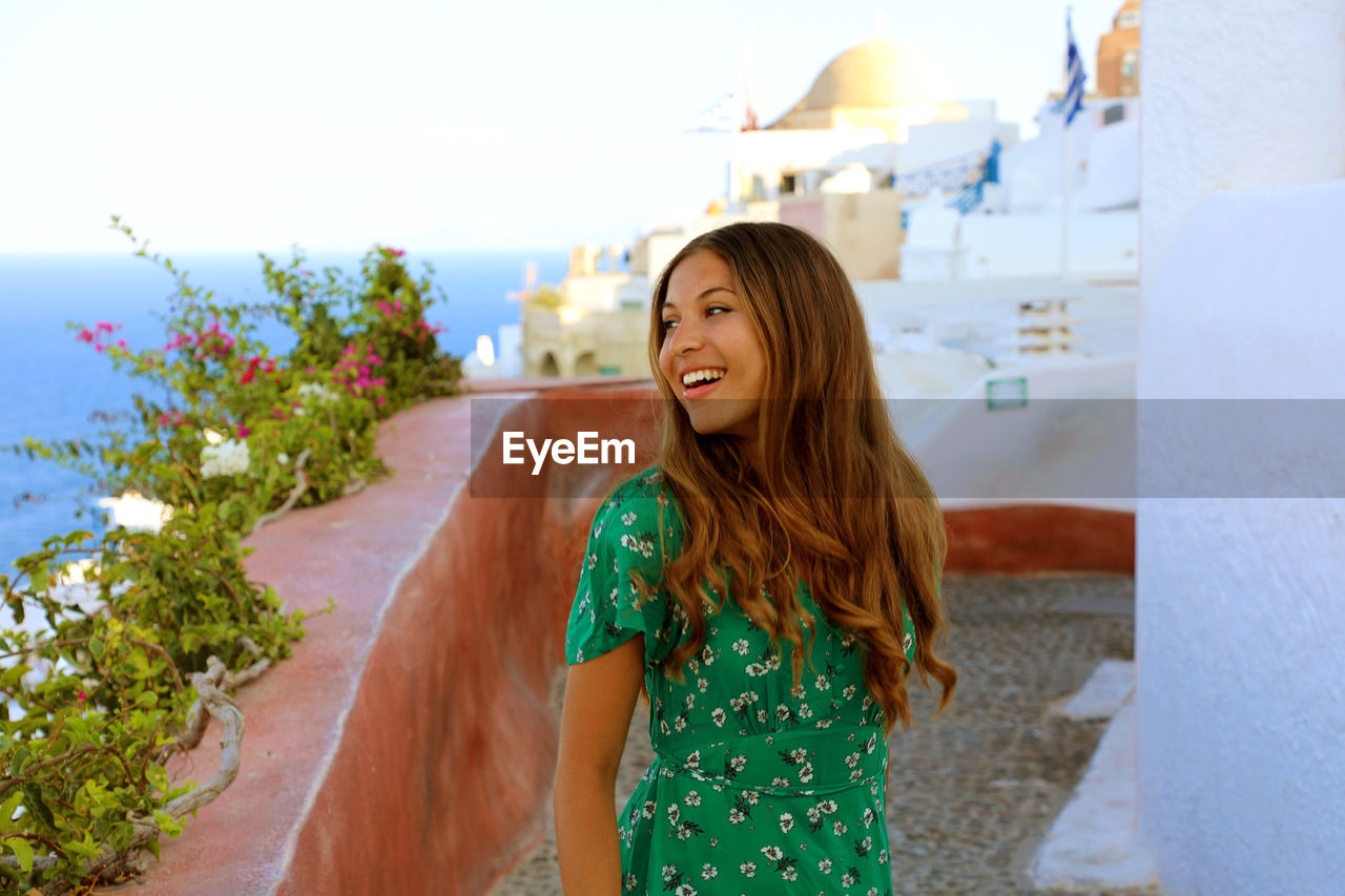 Smiling young woman looking away while standing outdoors