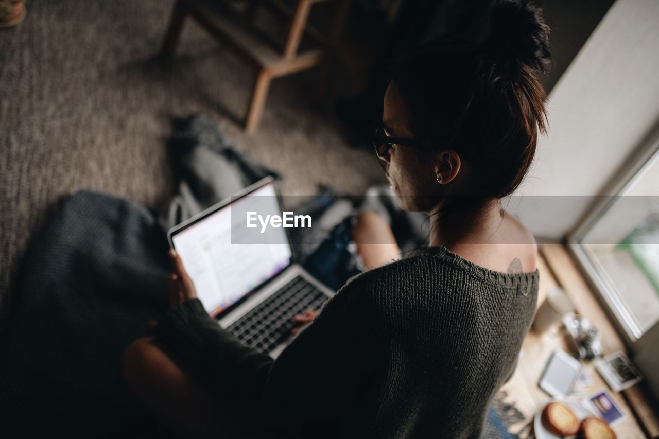 Woman using laptop while siting at home