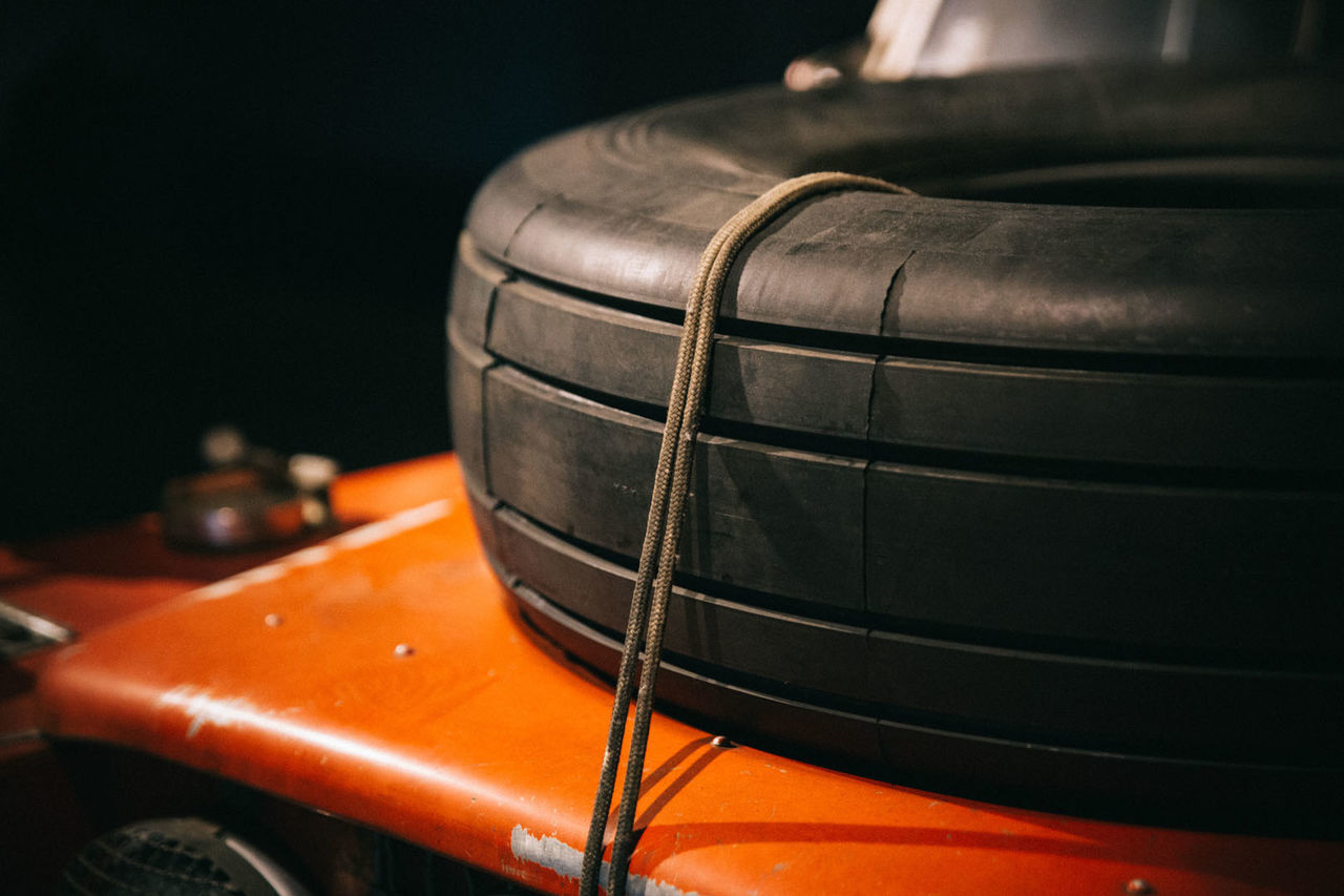 Close-up of tire on orange surface at workshop