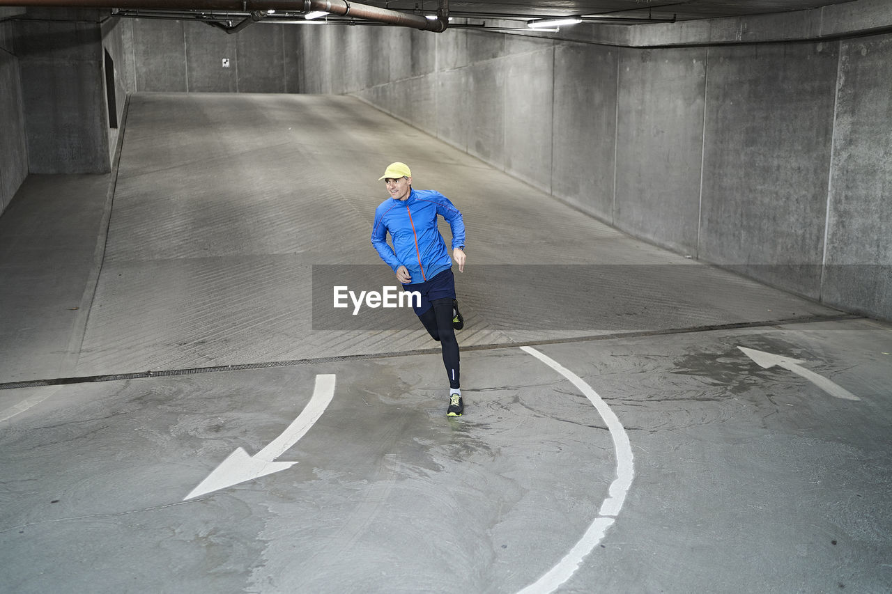 Mature man running in parking garage of residential building