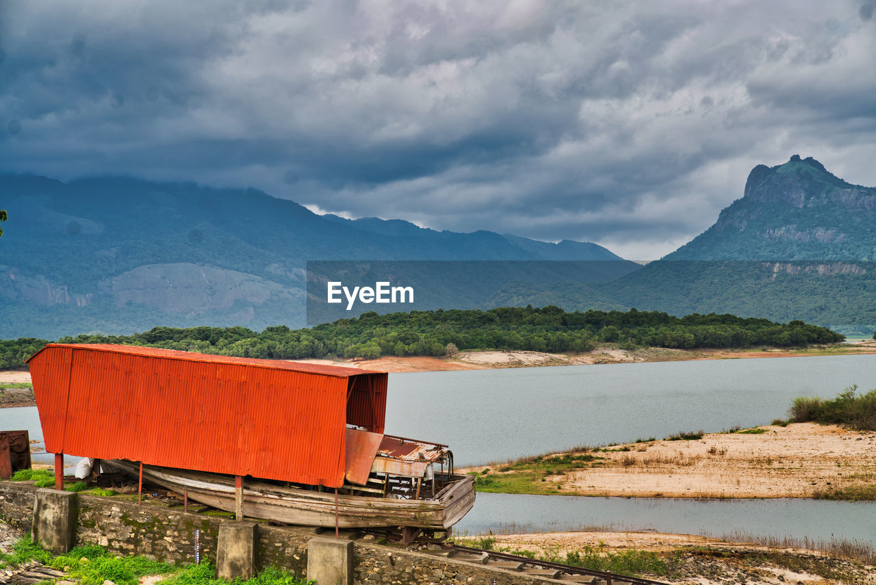 BUILT STRUCTURE BY LAKE AGAINST SKY