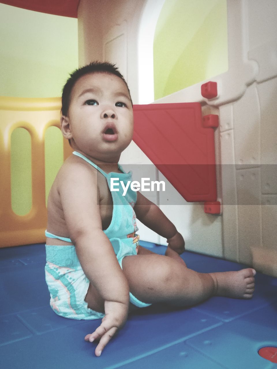 Toddler looking away while sitting in playhouse