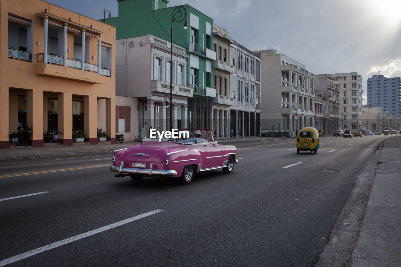 Vintage car moving on road in city