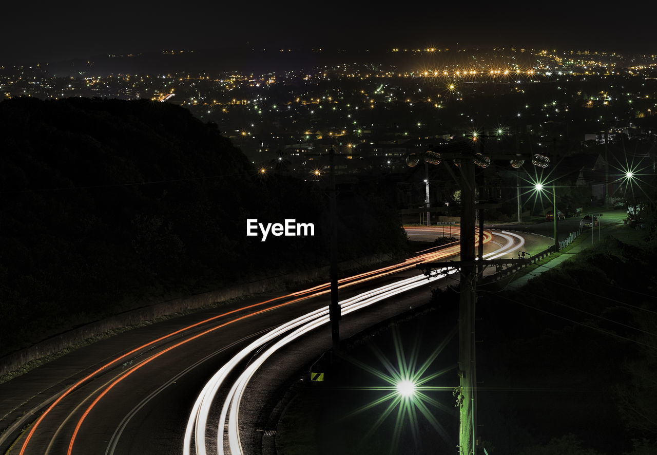 Illuminated light trail on highway at night