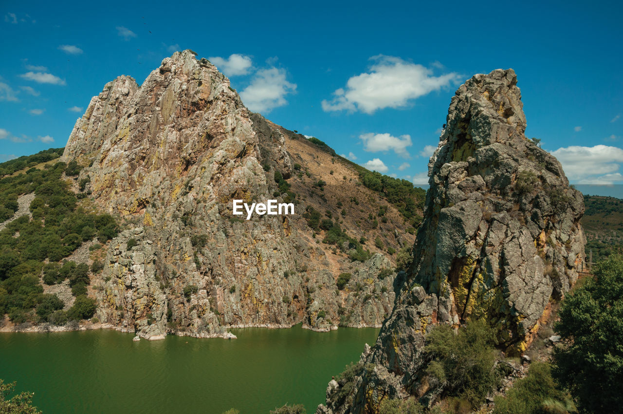 SCENIC VIEW OF LAKE AND ROCK FORMATION AGAINST SKY