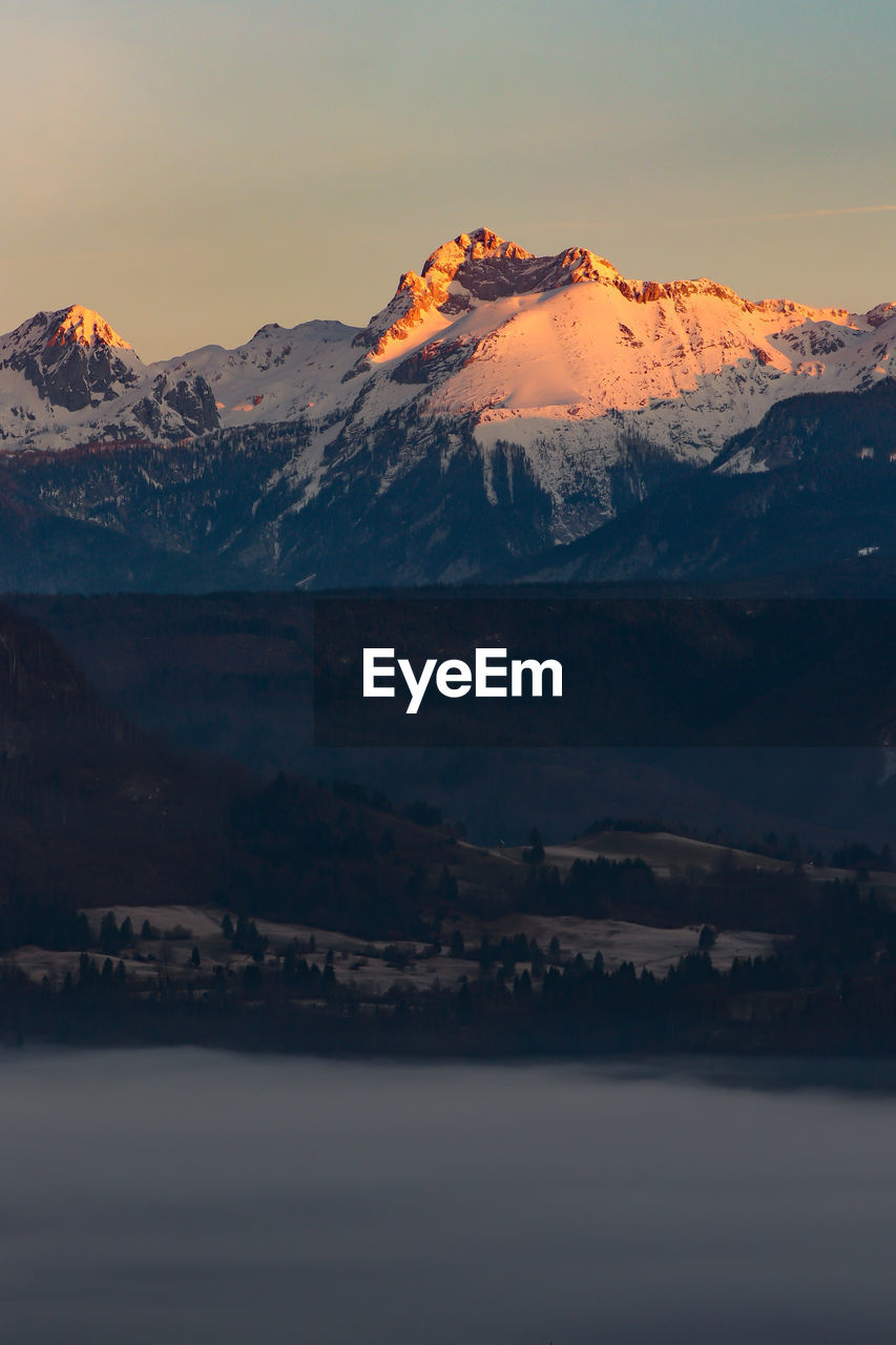 Scenic view of snowcapped mountains against sky during sunset