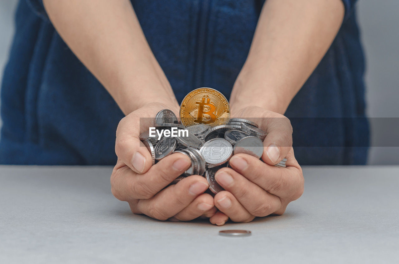 one person, finance, hand, currency, adult, coin, midsection, business, holding, close-up, front view, money, indoors, savings, ring, finance and economy, business finance and industry, wealth, jewellery, investment