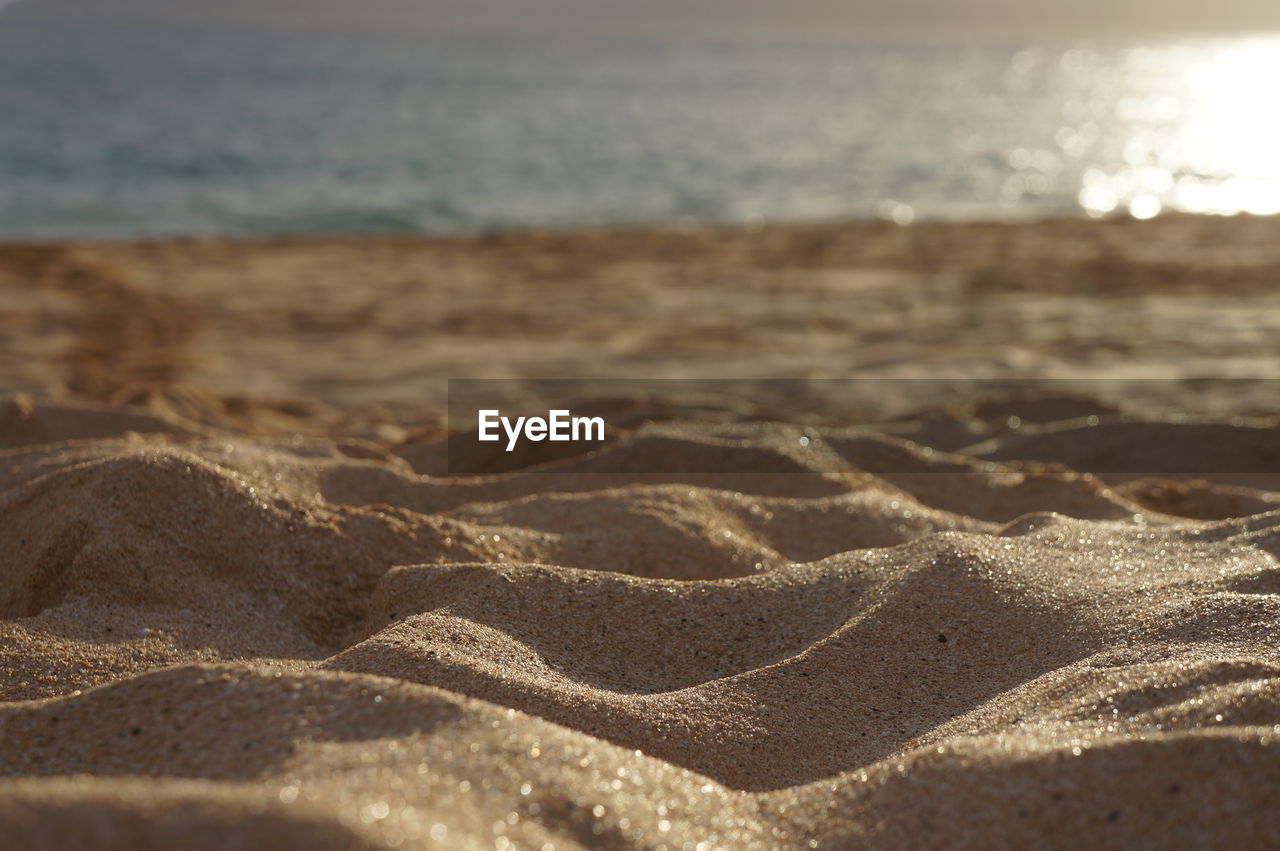 Surface level of sand on beach against water