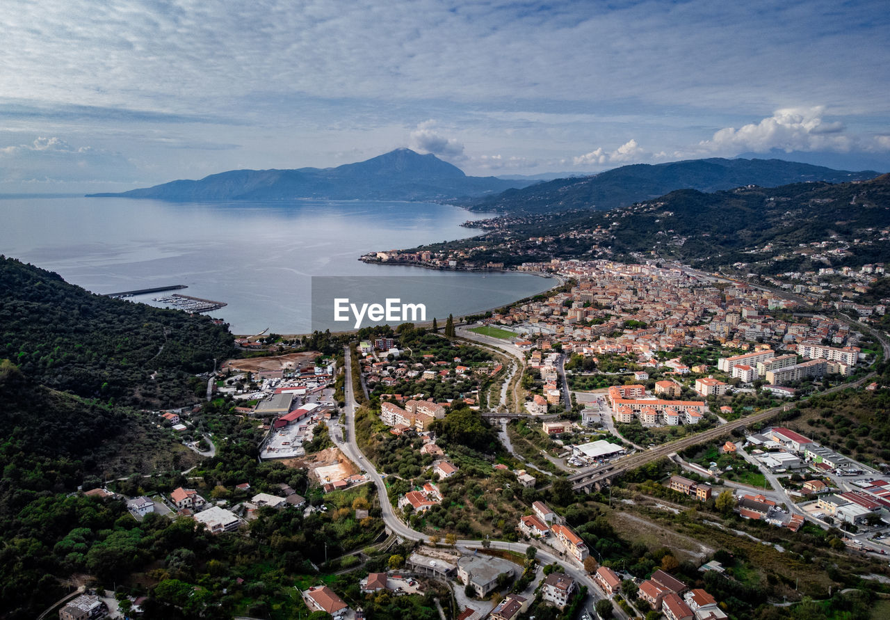 high angle view of city by sea against sky