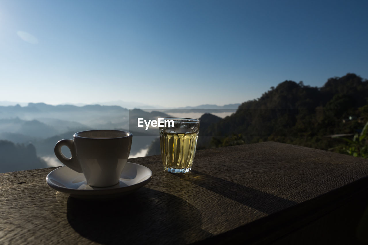 Coffee cup on table against sky