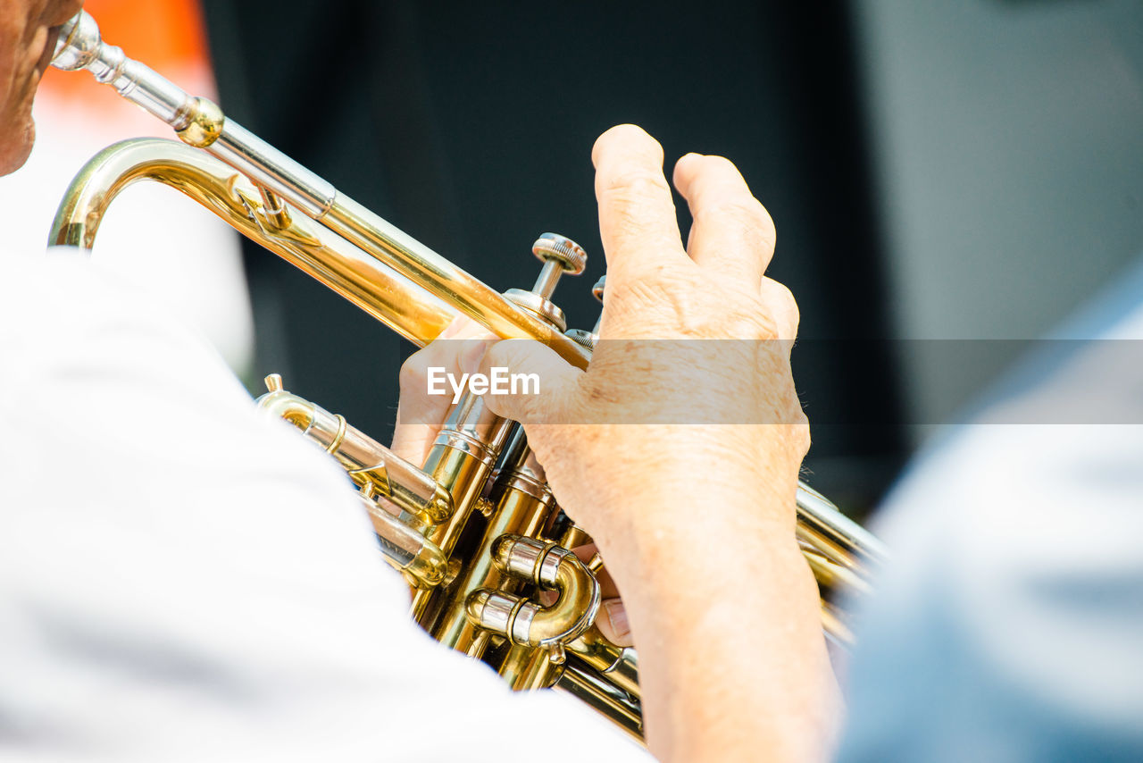 Midsection of man playing trumpet