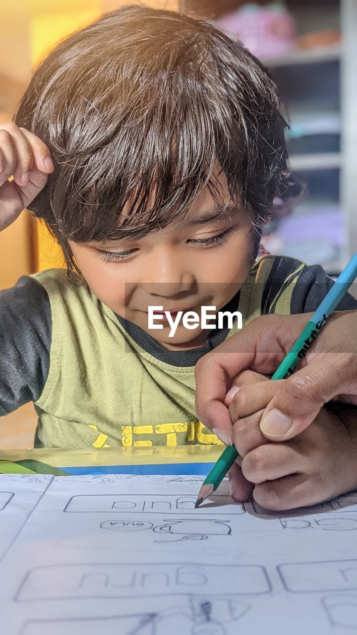 Close-up of boy drawing on book