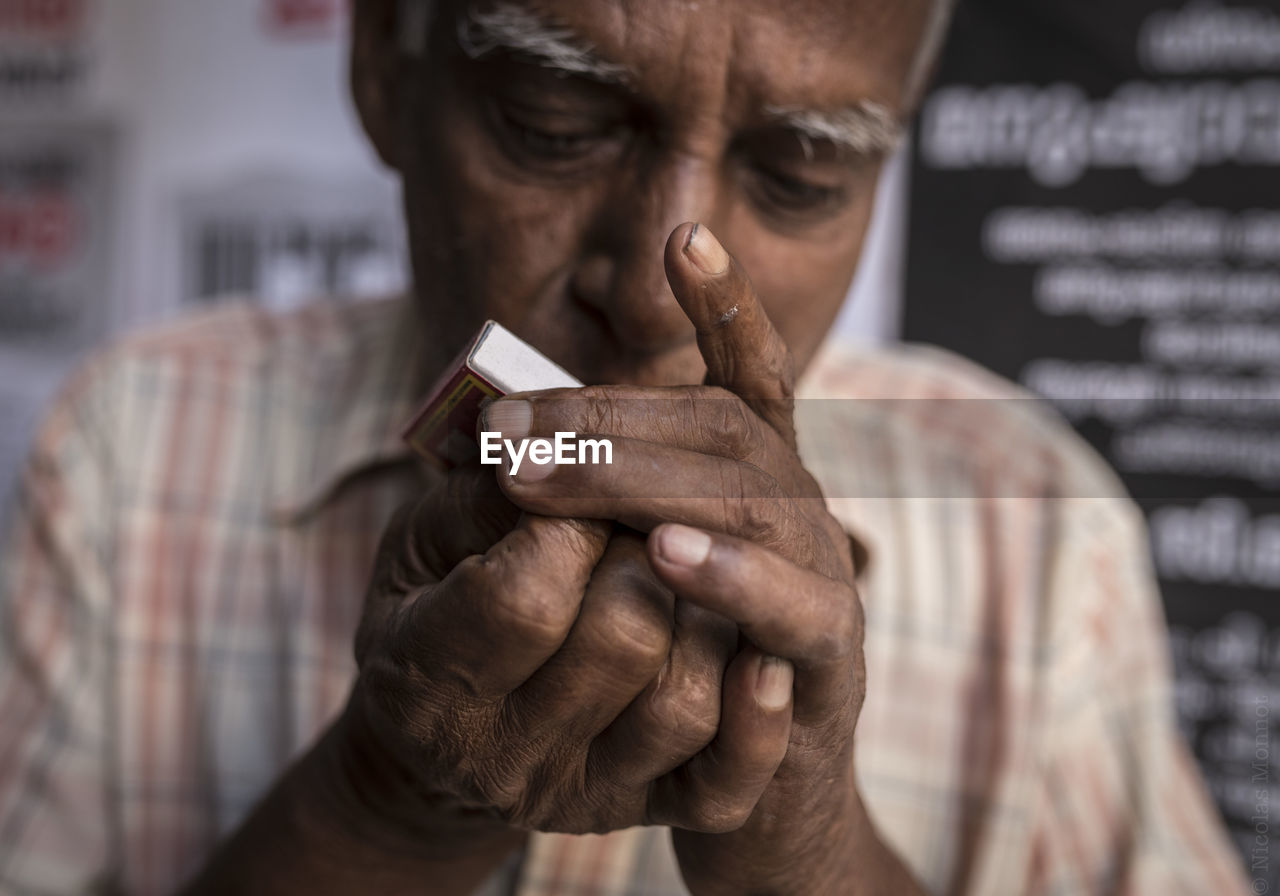 CLOSE-UP OF HAND HOLDING CIGARETTE