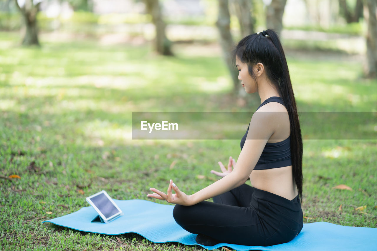 Young woman meditating in park