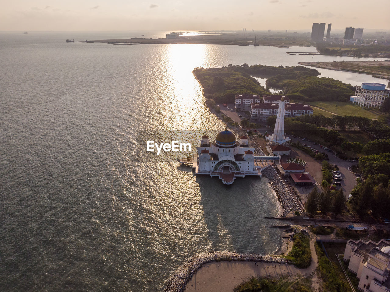 HIGH ANGLE VIEW OF BUILDINGS BY SEA DURING SUNSET